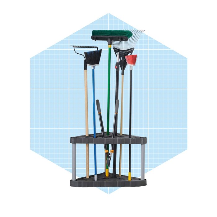 A stand holds various cleaning tools including brooms, rakes, and a pair of pruning shears against a light blue grid background.