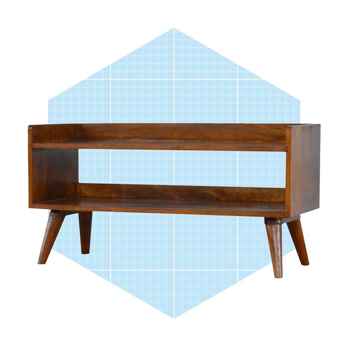 A wooden console table with open shelves stands on tapered legs against a light blue, grid-patterned background, emphasizing its modern design.