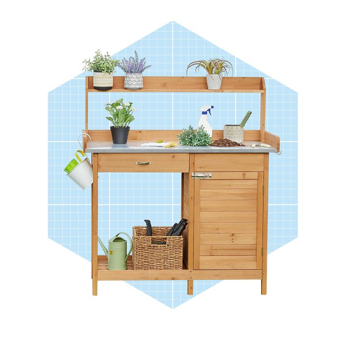 A wooden gardening bench holds potted plants and gardening tools, while a bottle and soil are nearby, set against a light blue grid background.