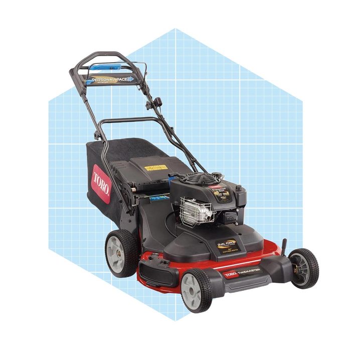 A lawn mower stands upright, with its handle positioned for guiding. It features a red base, black engine, and a grass collection bag against a blue grid background.