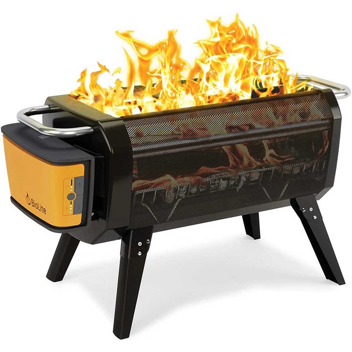 A black grill with a yellow panel produces vibrant flames, sitting on four sturdy legs, suggesting outdoor cooking or gathering.