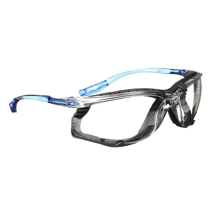 A pair of clear protective eyewear rests on a flat surface, featuring transparent blue and black frames, designed for safety during various activities.