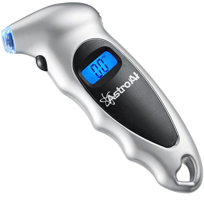 A digital tire pressure gauge displays a reading of 0.0 PSI, held in a hand with a sleek, ergonomic design and a blue backlight.