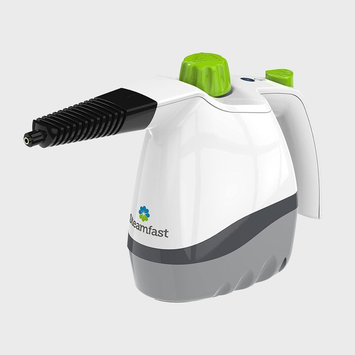A handheld steam cleaner is positioned upright, featuring a black nozzle and green controls, ready to release steam for cleaning purposes in various settings.