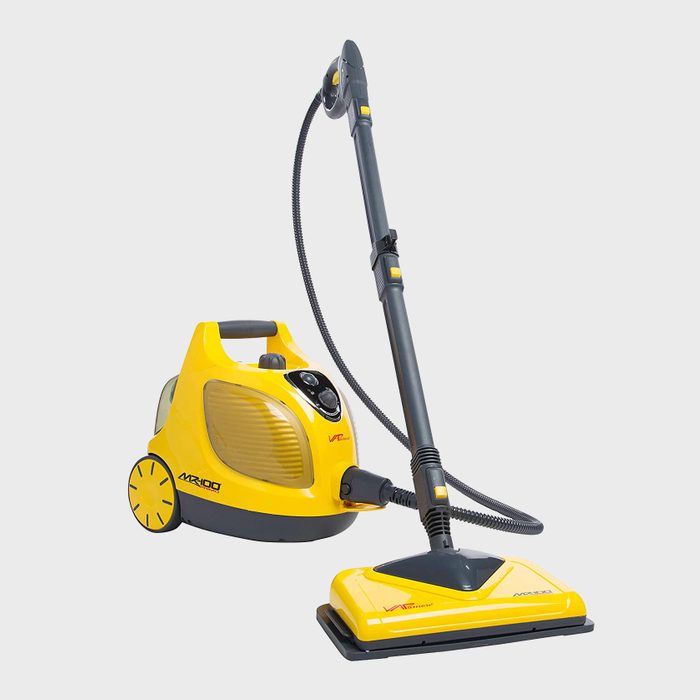 A yellow vacuum cleaner stands upright, with a long hose and attachment, ready for use on a neutral background.