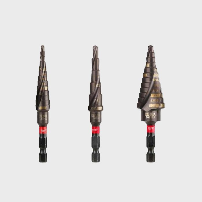 Three step drill bits with a spiral design are displayed. They are aligned side by side, each varying slightly in size and are mounted on red and black shafts.