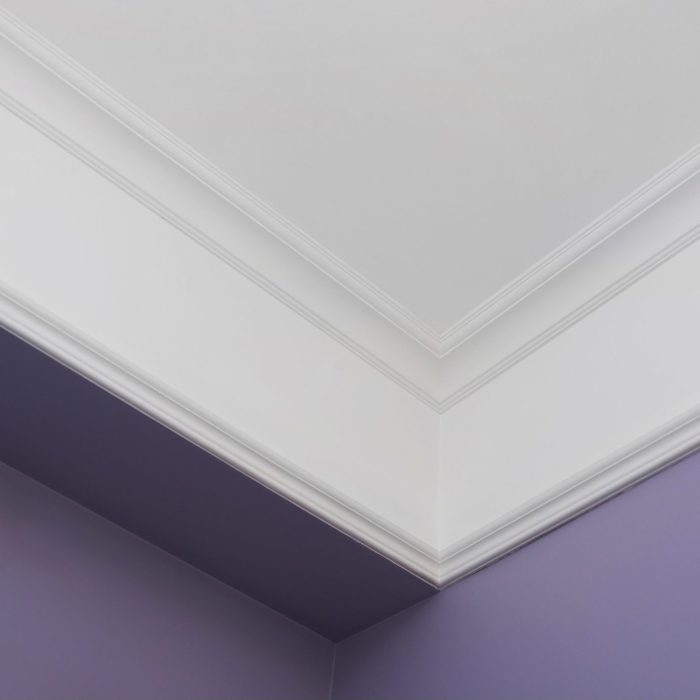 corner view of crown molding in an interior; purple walls, white ceiling with white crown molding