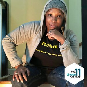 A person in casual clothing sits confidently on stairs, wearing a gray hoodie and a black 