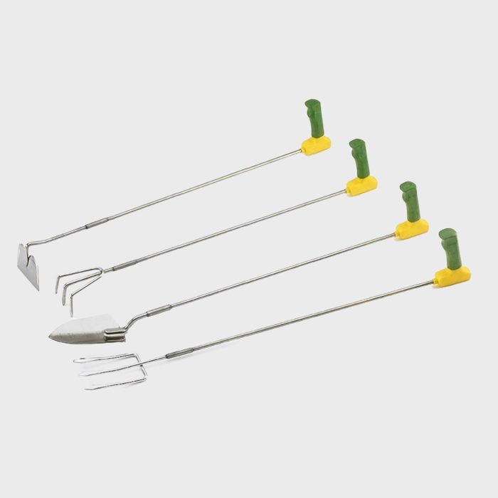 Four garden tools with long metal handles and colorful plastic grips are arranged in a line, ready for planting or cultivating soil.