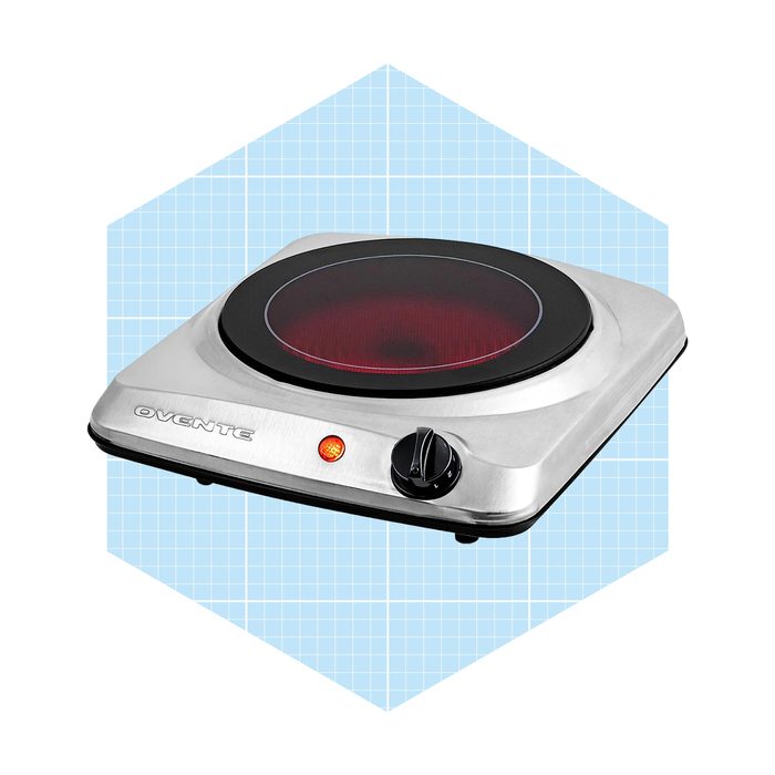 A portable electric burner heats up, indicated by a red glow, set against a light blue grid background for a modern kitchen context.