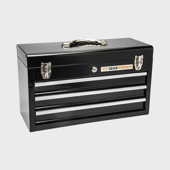 A black toolbox rests upright, featuring three drawers. Its polished metal handle and locks indicate secure storage for tools, designed for organization in workshops.