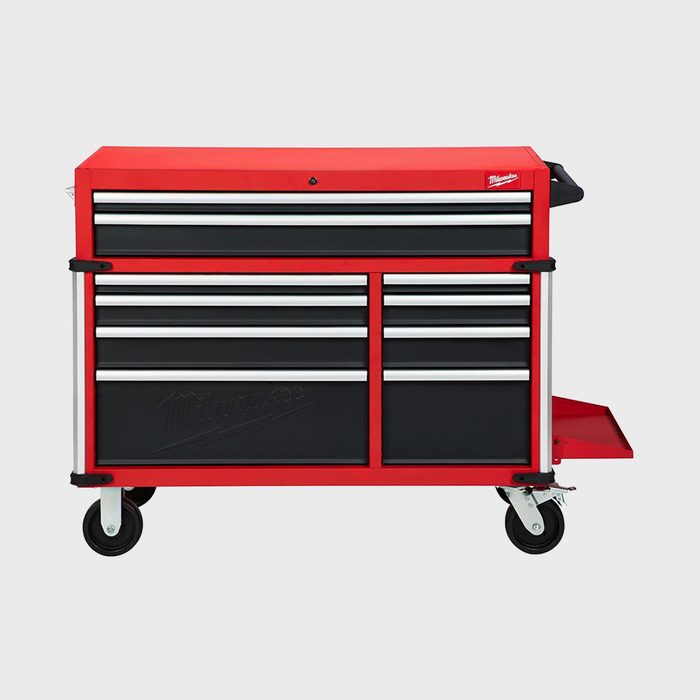 A red tool chest with multiple drawers stands on wheels, providing storage for tools and easy mobility in a workshop or garage environment.