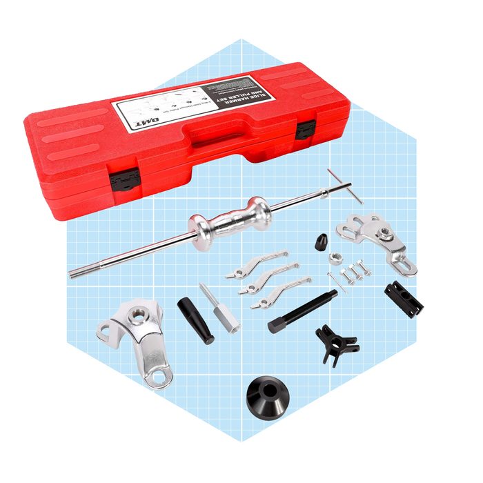 A red tool case contains various automotive tools, including a puller and attachments, arranged neatly on a light blue grid background.