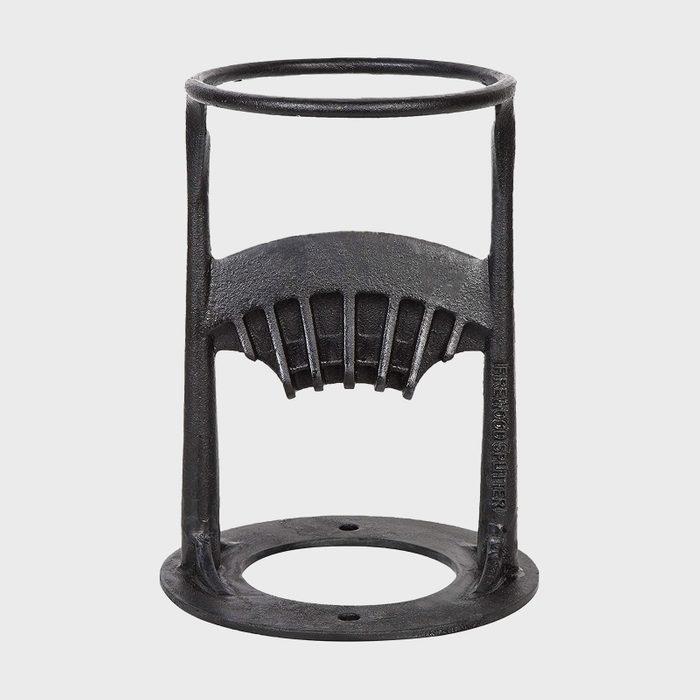 A black metal bottle opener stands upright, designed to grip bottles; it features a circular top and a sturdy base on a plain white background.