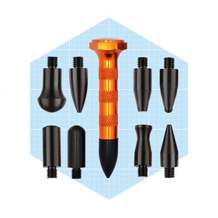 An orange aluminum tool with a textured grip is surrounded by various black interchangeable tips, resting on a light blue grid background.