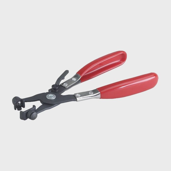 A pair of red-handled pliers grips an object, designed for precision tasks in a workshop setting, showcasing its functional and ergonomic design.