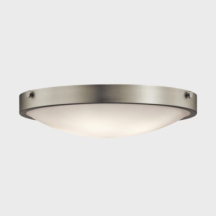 A circular ceiling light fixture emits soft, diffused light, mounted on a brushed metal base against a neutral background.