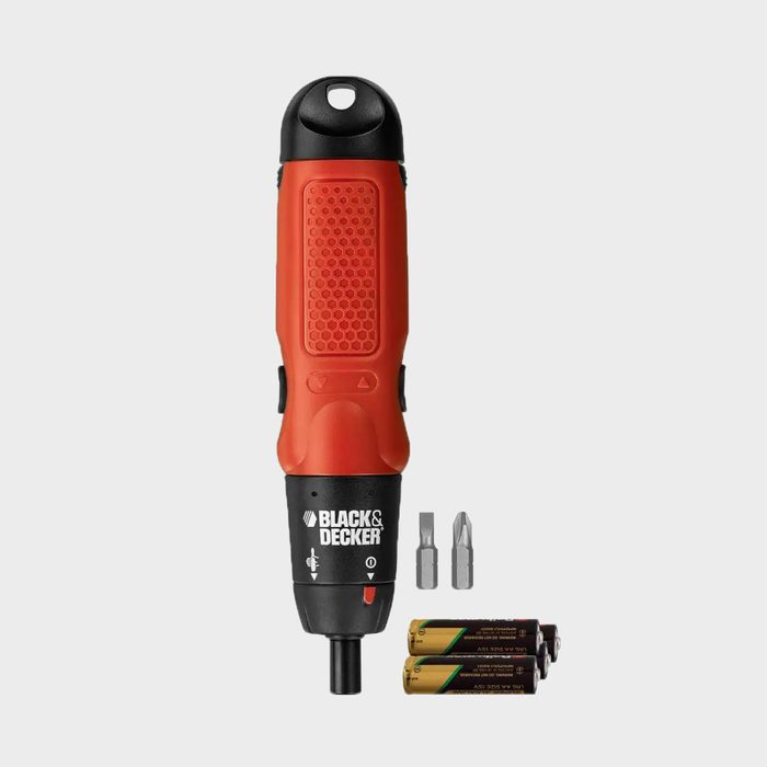 A red and black electric screwdriver stands upright, with interchangeable bits and two batteries placed beside it, suggesting readiness for assembly tasks.