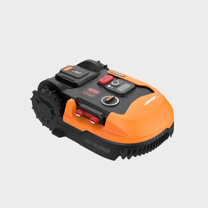A small robotic lawn mower, equipped with buttons and charging ports, is positioned on a light background, designed for cutting grass efficiently.