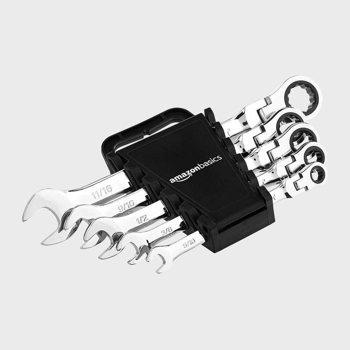 A set of five wrenches is stored in a black holder, displaying various sizes for mechanical tasks in a workshop or garage environment.