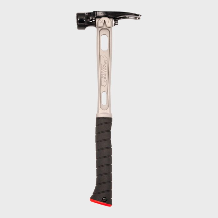A claw hammer stands upright, its metal head glinting. The rubber grip provides comfort for striking. The background is plain and unobtrusive.