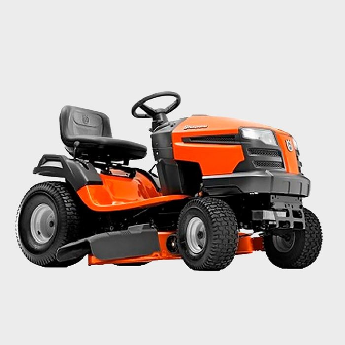 A riding lawn mower with a black seat and orange body, parked on a flat surface, designed for mowing grass efficiently in gardens or yards.