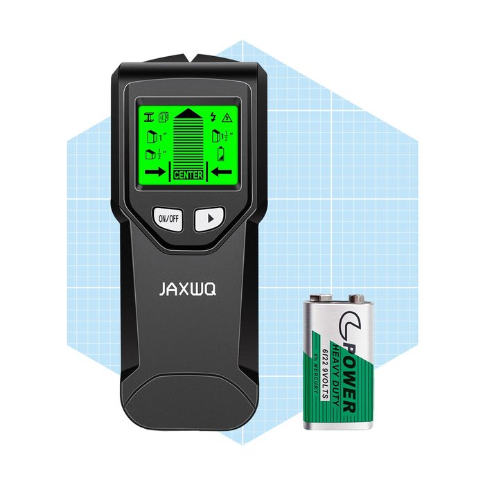 A digital measuring tool displays measurements on a green screen while sitting next to a battery, set against a light blue grid background.