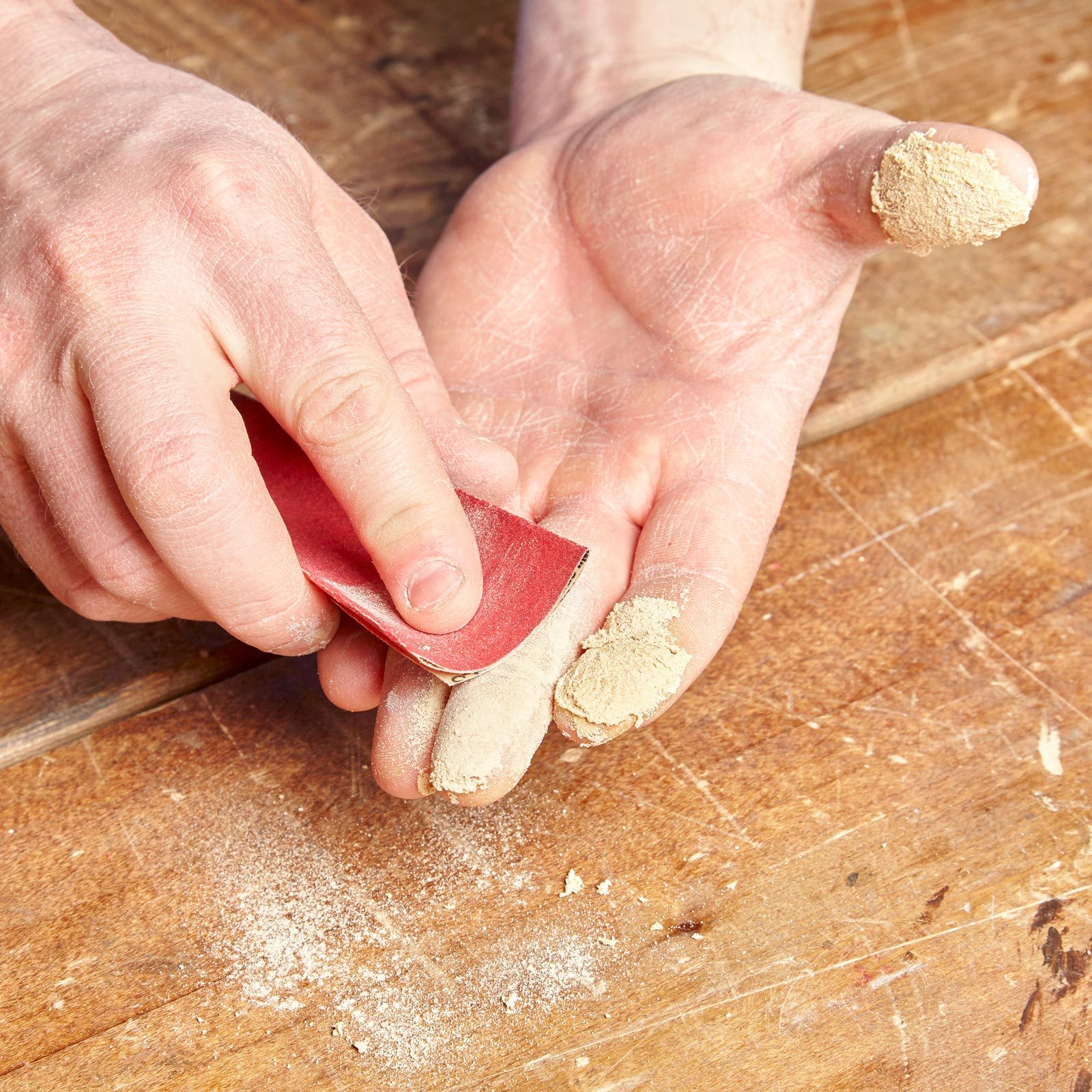 person using sandpaper to sand hands