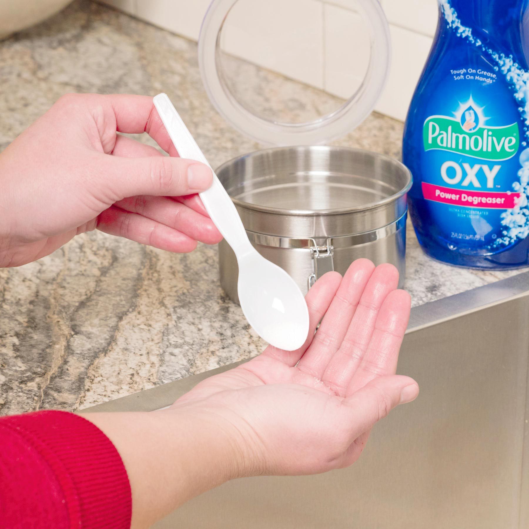 close up of hands using a spoon to apply handmade soap