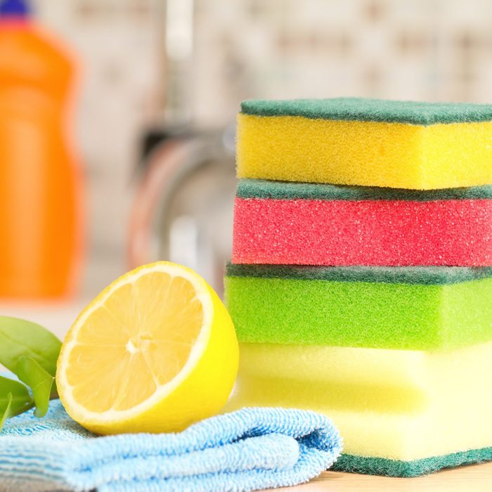 stack of colorful sponges with a sliced lemon in a kitchen for cleaning