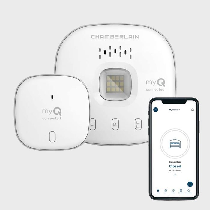 A white smart garage door controller and sensor connect to a smartphone displaying the door