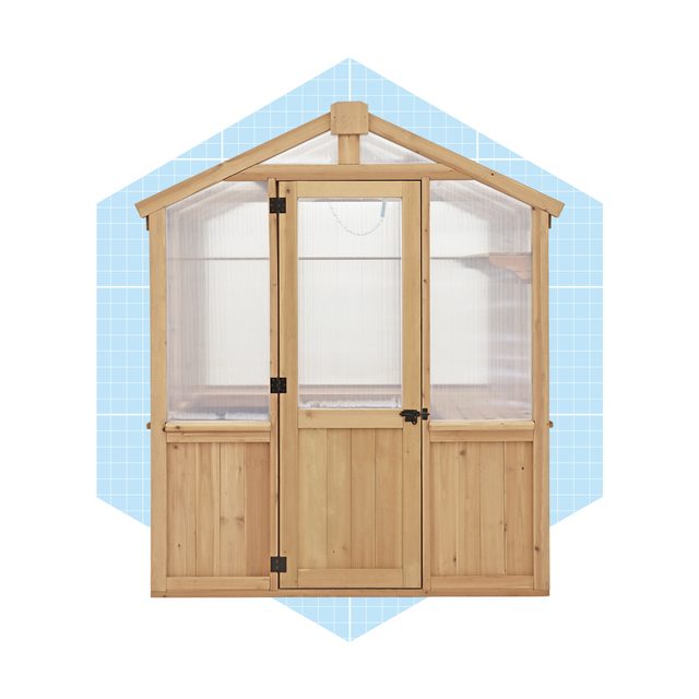 A wooden greenhouse stands upright, featuring double doors at the front, allowing light and ventilation, against a light blue geometric background.