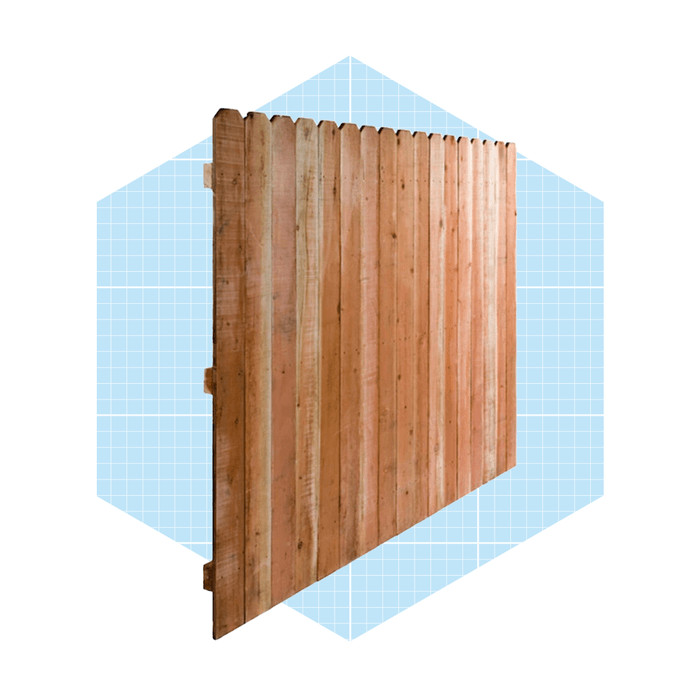 A wooden fence panel stands upright, showcasing vertical slats, against a light blue grid background, emphasizing its structure and design.