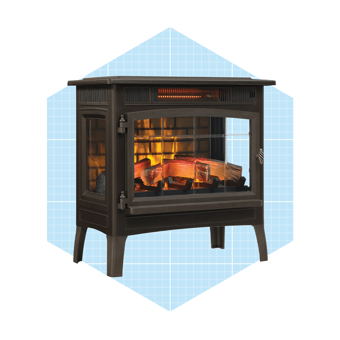 A black electric fireplace displays glowing logs behind a glass front, providing warmth and light, set against a light blue grid background.