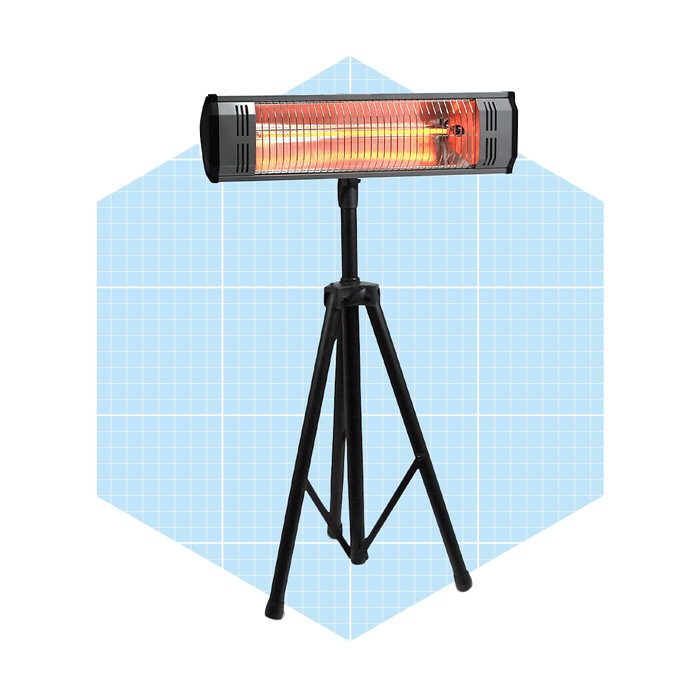 A standing infrared heater emits orange light, illuminating its surroundings, set against a light blue grid-patterned background.