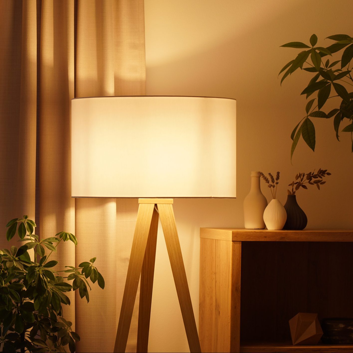 View of tripod lamp in a cozy living room spending warm light