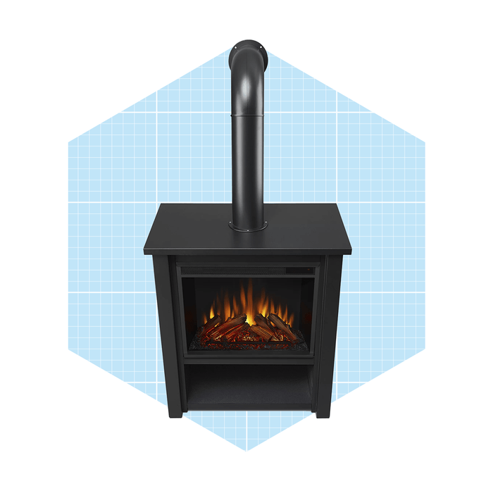 A black fireplace emits glowing flames, resting on a flat surface within a light blue, grid-patterned background, enhancing its modern aesthetic.