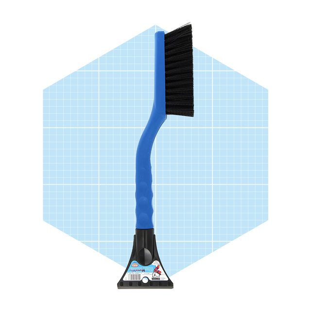 A blue-handled brush with stiff bristles stands upright against a light blue grid background, designed for cleaning surfaces or removing debris.