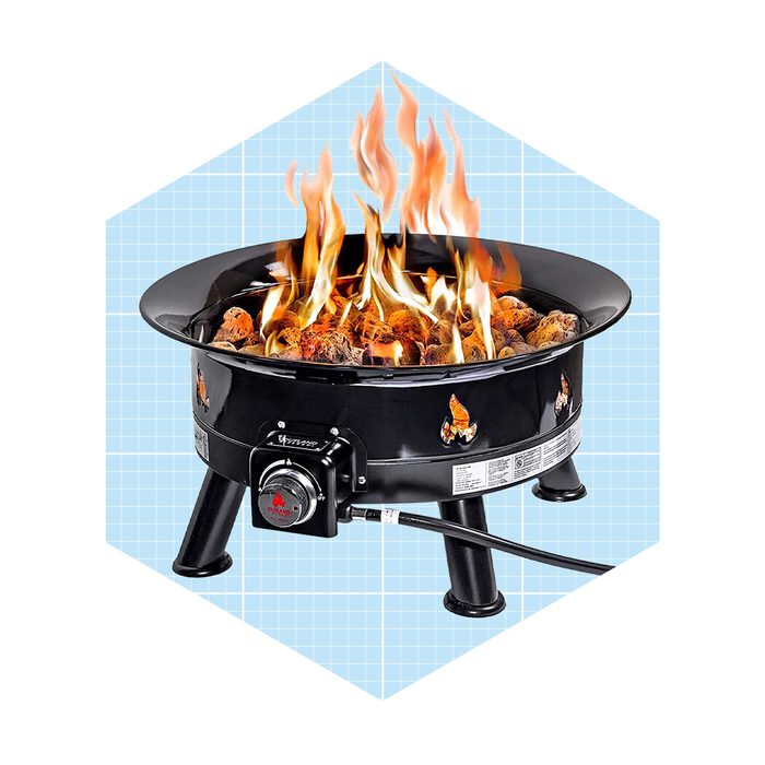 A black fire pit burns brightly with flames rising from charcoal. It stands on three legs against a light blue grid background.
