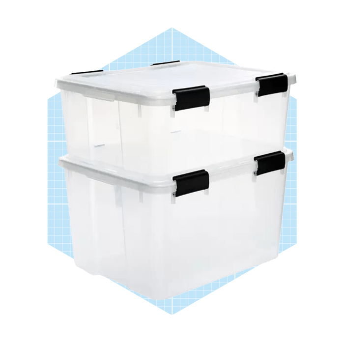 Two transparent storage containers are stacked, each with a secure lid and black clips, set against a light blue grid background.