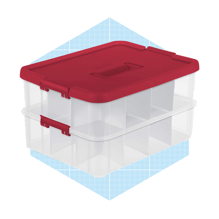 A transparent storage container with a red lid holds multiple compartments, positioned on a light blue grid-patterned background.