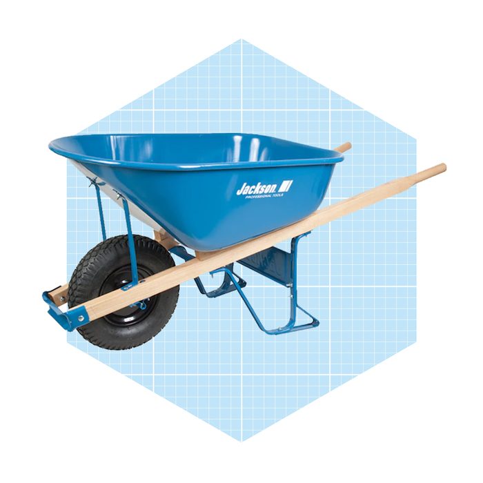 A blue wheelbarrow stands on a flat surface, featuring a sturdy wooden handle and a single wheel, set against a light blue grid background.