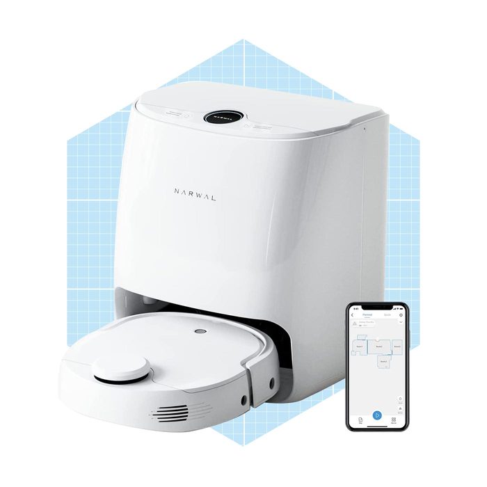 A robotic vacuum cleaner stands on a blue grid background. It appears ready to clean, with a mobile app displaying a map nearby.