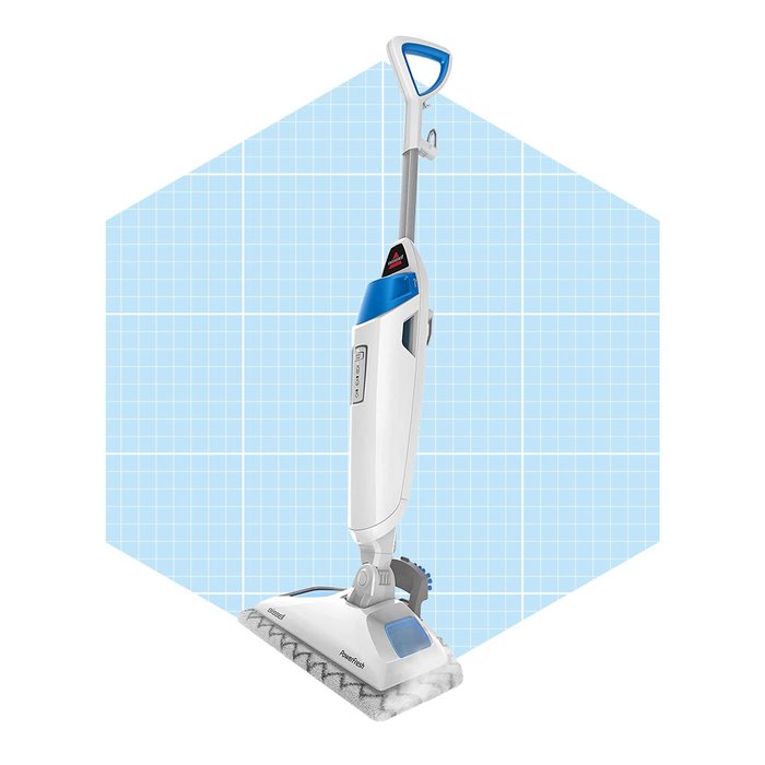 A steam mop stands upright, ready for use, with a blue and white design against a light blue grid background, indicating a cleaning tool.