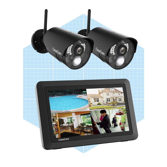 Two wireless security cameras are positioned above a display screen showing live feeds of various locations, including a pool, house exterior, and interior scenes.