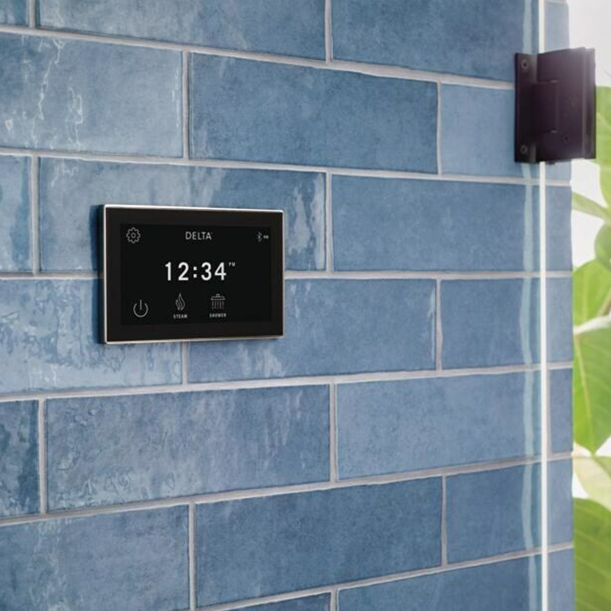 A digital control panel displays time and settings on a blue tiled wall, managing steam and shower functions in a bathroom environment.