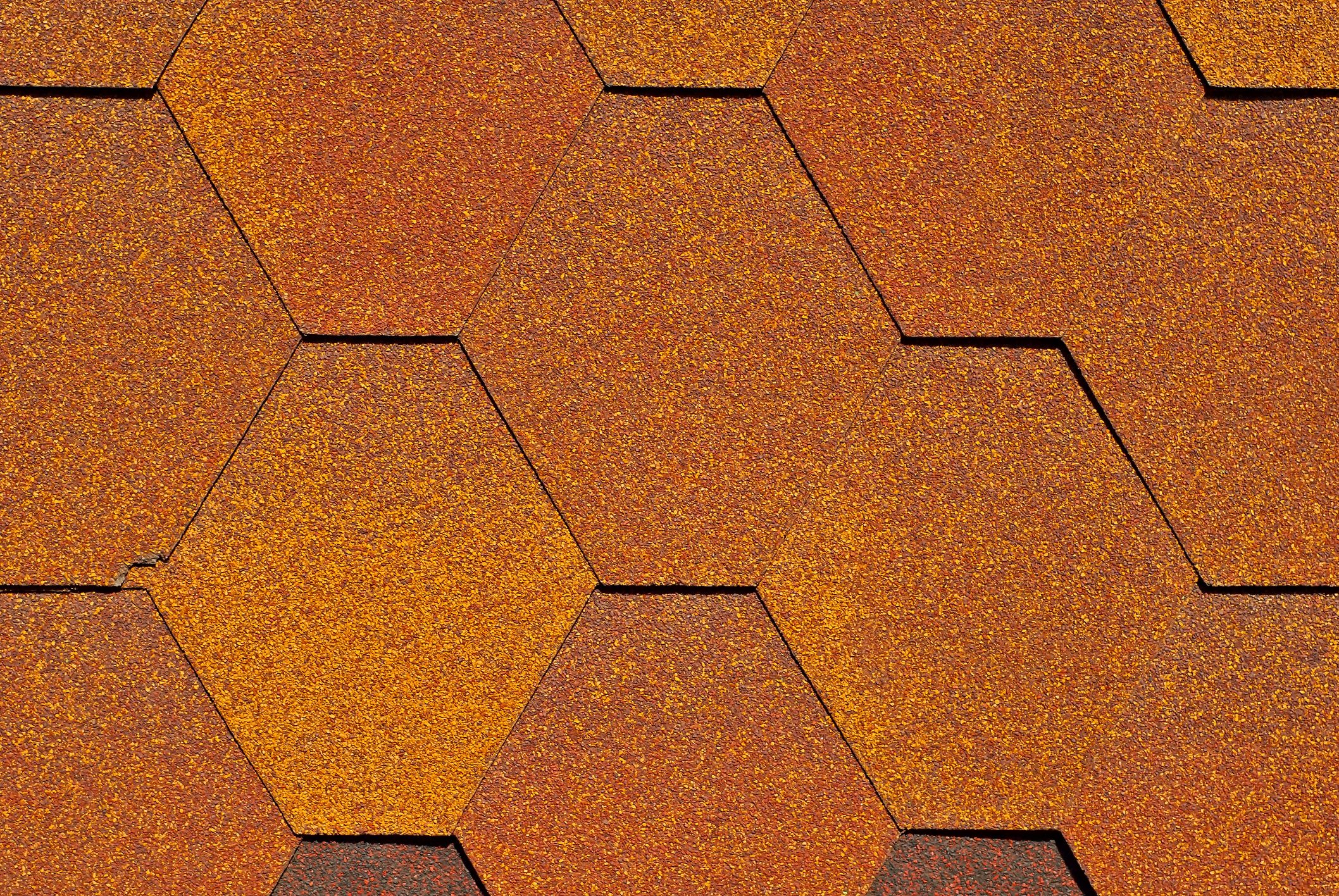 Flexible tile is made of fiberglass impregnated with bitumen. Texture of orange roof close up.