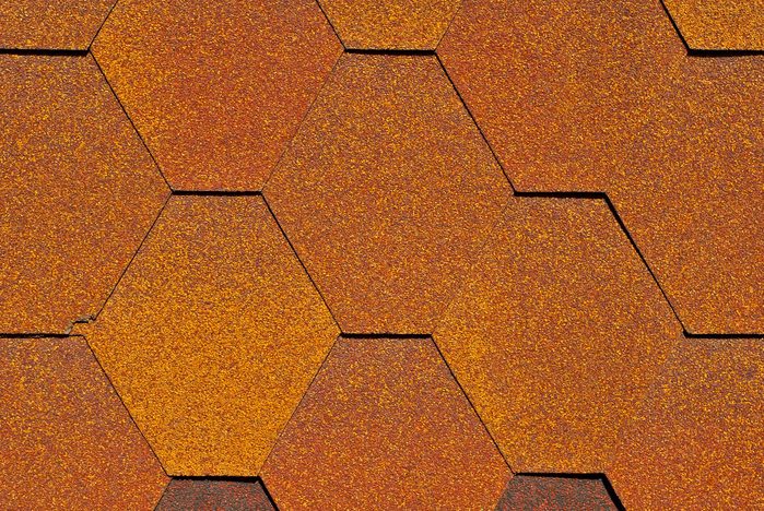 Flexible tile is made of fiberglass impregnated with bitumen. Texture of orange roof close up.