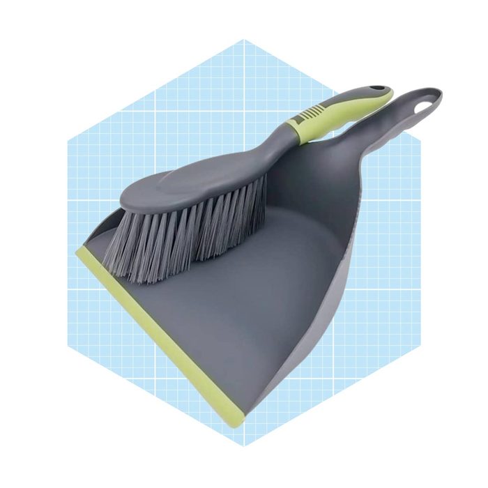 A gray dustpan with a matching broom rests together. They are on a light blue grid background, ready for cleaning tasks.