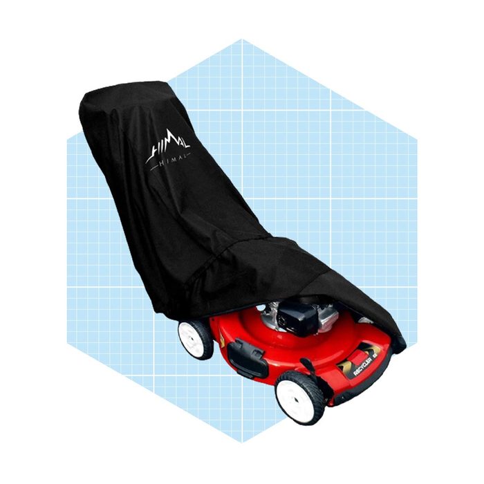 A red lawn mower is covered by a black protective cover, resting on a light blue grid background, indicating storage or protection from the elements.